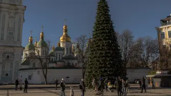 Residentes locales caminan cerca del principal árbol de Navidad de Kiev, en la plaza de Santa Sofía, el 13 de diciembre de 2025, durante la invasión rusa de Ucrania.