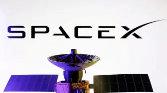 SpaceX logo and miniature satellite model are seen in this illustration created on March 10, 2025. REUTERS/Dado Ruvic/Illustration