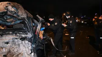 La policía ucraniana inspeccionan un coche destrozado con el cadáver de una víctima en el lugar del impacto de un ataque en Járkov, el 26 de diciembre de 2025.