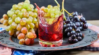 Bunch of grapes and a glass of juice on dark background. High quality photo