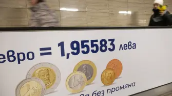 Commuters walk along a moving walkway in Sofia's subway beside an advertisement promoting Bulgaria's entry into the Eurozone on December 31, 2025, ahead of the country's adoption of the euro on January 1, 2026. (Photo by Nikolay DOYCHINOV / AFP)