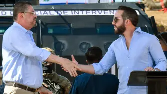 El Salvador's President Nayib Bukele (R) and Costa Rica's President Rodrigo Chaves shake hands after a press conference at the construction site of the High Containment Center for Organized Crime (CACO) prison in Alajuela, Costa Rica on January 14, 2026. (Photo by EZEQUIEL BECERRA / AFP)