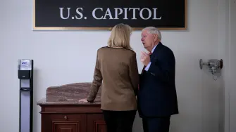 La senadora Lisa Murkowski (republicana por Alaska) (izq.) es apartada por el senador Lindsey Graham (republicano por Carolina del Sur) en el sótano del Capitolio de los Estados Unidos antes de la votación sobre una resolución sobre los poderes de guerra en Venezuela.