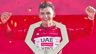 Championship first place winner UAE Team Emirates's Mexican rider Isaac Del Toro Romero celebrates with the trophy on the podium after the seventh and final stage of the UAE Tour cycling event from Zayed National Museum to Abu Dhabi Breakwater in Abu Dhabi on February 22, 2026. (Photo by Fadel SENNA / AFP)