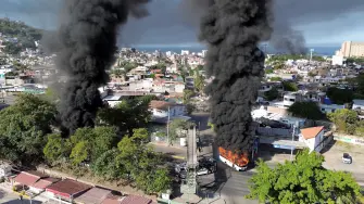 Smoke billows from burning vehicles amid a wave of violence, with torched vehicles and gunmen blocking highways in more than half a dozen states, following a military operation in which a government source said Mexican drug lord Nemesio Oseguera, known as "El Mencho," was killed, in Puerto Vallarta, Jalisco, Mexico, February 22, 2026, in this screen grab obtained from a social media video. @morelifediares via Instagram/Youtube/via REUTERS  THIS IMAGE HAS BEEN SUPPLIED BY A THIRD PARTY. MANDATORY CREDIT. NO RESALES. NO ARCHIVES. TPX IMAGES OF THE DAY  Verification: Reuters confirmed the location as Puerto Vallarta by the road layout, trees, buildings and businesses logos which matched file and satellite imagery. The shape of the mountains matched topography mapping. The date when the videos were filmed was verified by original file metadata.