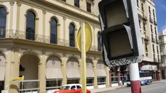 A car drives past a traffic light that is out due to a power cut in Havana on March 4, 2026. (Photo by YAMIL LAGE / AFP)
