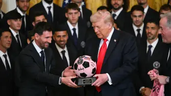 Argntinian star Lionel Messi hands US President Donald Trump a ball during an event for Inter Miami CF, winners of the 2025 Major League Soccer Cup, in the East Room of the White House in Washington, DC, on March 5, 2026. (Photo by ANDREW CABALLERO-REYNOLDS / AFP)