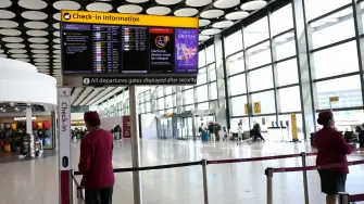 FILE PHOTO: Qatar airline staff stand by a departure board displaying cancelled flights to Middle East countries amid the U.S.-Israel conflict with Iran, at Heathrow Airport Terminal 4, in Greater London, Britain, March 2, 2026. REUTERS/Isabel Infantes/File Photo