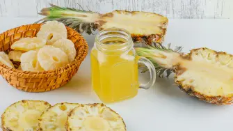 Pineapples with juice, candied rings on white and grungy background, high angle view.