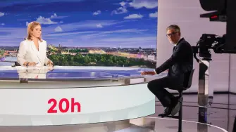 El secretario general del Partido Socialista Francés, Olivier Faure, posa junto a la presentadora de televisión Lea Salame en el plató antes de una entrevista en el informativo vespertino del canal de televisión francés France2.