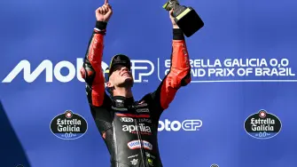 El piloto italiano de Aprilia Racing, Marco Bezzecchi, celebra con el trofeo en el podio.