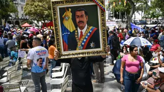 A supporter of Venezuela's ousted president Nicolas Maduro holds a painting depicting Maduro during a demonstration in Caracas on March 26, 2026, as he appeared in court in New York. Ousted Venezuelan president Nicolas Maduro was back in a New York court on March 26, 2026 for his second appearance since his capture by US forces in an extraordinary nighttime raid. (Photo by Juan BARRETO / AFP)