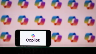 This photograph shows the logo of Microsoft conversational and AI-powered assistant, Copilot, on a phone and a screen, in Mulhouse on October 28, 2025. (Photo by SEBASTIEN BOZON / AFP)