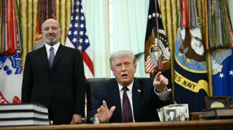 US President Donald Trump (R) speaks as Commerce Secretary Howard Lutnick (L) looks on after signing an executive order in the Oval Office of the White House in Washington, DC, on March 31, 2026. (Photo by Brendan SMIALOWSKI / AFP)