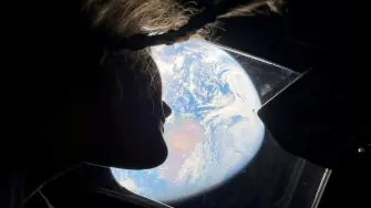 La astronauta de la NASA y especialista de la misión Artemis II, Christina Koch, mira por una de las ventanas de la cabina principal de la nave espacial Orion, observando la Tierra, mientras la tripulación viaja hacia la Luna. Imagen del 2 de abril de 2026.