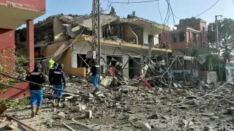 Los servicios de emergencia se congregan en el lugar donde un ataque aéreo israelí tuvo como objetivo un barrio de la aldea de Kfar Roummane, en el sur del Líbano, el 13 de abril de 2026.