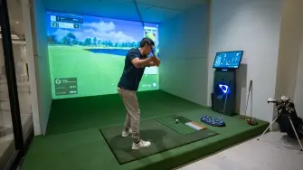 Usuario utiliza simulador de golf, una amenidad que, según Side Sports, se integra a espacios inmobiliarios.