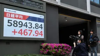 A camera crew films a display of the Nikkei Stock Average near the Tokyo Stock Exchange in Tokyo on April 20, 2026. (Photo by Andrew CABALLERO-REYNOLDS / AFP)