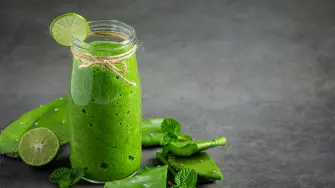 a glass of aloe vera  juice put on dark floor