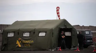 Members of the Spanish Civil Guard wait for the arrival of the Cruise MV Hondius at port of Granadilla de Abona on the island of Tenerife in Spain's Canary Islands on May 9, 2026. A cruise ship hit with a deadly hantavirus outbreak is expected to reach waters off Tenerife at dawn, with WHO chief also due on the archipelago to help coordinate the ship's evacuation. (Photo by JORGE GUERRERO / AFP)