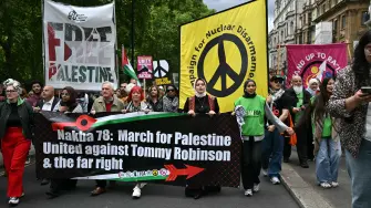 Manifestantes con banderas y pancartas palestinas marchan por Piccadilly, en el centro de Londres, durante una protesta en conmemoración de la Nakba en apoyo a Palestina y contra la extrema derecha.