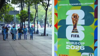 Workers wal near an image of the World Cup 2026 logo during an exhibition of the Panini World Cup Album at the Reforma Avenue in Mexico City on May 11, 2026. In one month, the World Cup begins with the opening match at the Mexico City Stadium, between Mexico and South Africa. (Photo by Alfredo ESTRELLA / AFP)