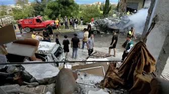 Personas inspeccionando los daños causados ​​por un bombardeo israelí a un edificio en la aldea de Saksakiyeh, en el sur del Líbano.