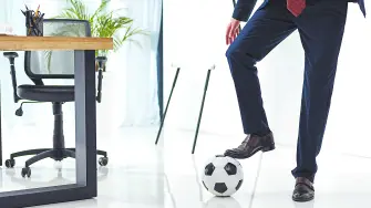 cropped shot of businessman with soccer ball at workplace in office
