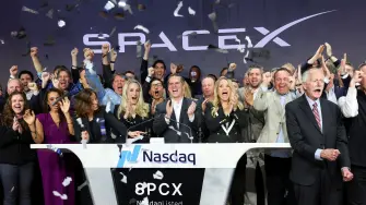 La presidenta de SpaceX, Gwynne Shotwel, y el director financiero, Bret Johnsen, acompañados de líderes de la compañía en el campanazo de la salida a Bolsa.