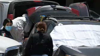 Los peritos forenses inspeccionaron una camioneta Toyota en la que supuestamente se encontró un cadáver en un estacionamiento en las inmedicaciones de un estadio en Tijuana.