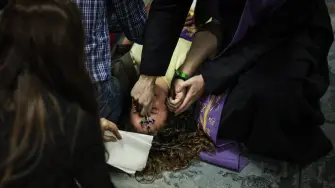 Self-proclaimed priest, not recognized by the Catholic Church, Francisco Marques, 27 years old, places his hands on a womans forehead as she lies on the floor, during a "exorcist retreat" where he claims to cast out demons afflicting his followers, organized by the "Prelature of Saints Peter and Paul in Fatima on May 30, 2026. The scene unfolds not in a church but in the basement of a small shopping centre a short walk from the vast esplanade of Portugal's famed Fatima shine, one of the Catholic Church's most visited pilgrimage sites.The gathering was part of a series of monthly "exorcism retreats" held in Fatima that have raised concerns among Catholic authorities, who say they operate outside official Church oversight by self-styled religious figures and risk exploiting vulnerable believers. (Photo by PATRICIA DE MELO MOREIRA / AFP)