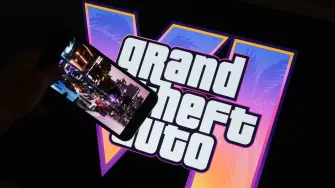 (FILES) This illustration photo created in Los Angeles, December 4, 2023, shows Rockstar Games Grand Theft Auto VI trailer played on a screen in front of the game title. Thirteen years of waiting are about to come to an end: the video game "Grand Theft Auto VI," the latest installment in the saga from US studio Rockstar Games, opens for pre-orders on June 25, 2026, and is poised to become the biggest launch of a cultural product in history. (Photo by Chris DELMAS / AFP)