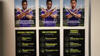 Posters show the FIFA three-step procedure against racism and discriminatory behaviour at the locker rooms of the Dallas Stadium in Arlington on July 12, 2026, ahead of the 2026 World Cup football tournament semi-final match between France and Spain on July 14.  (Photo by FRANCK FIFE / AFP)