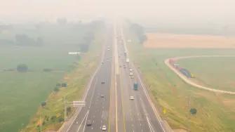 Vehículos circulan por la autopista 401 mientras el humo de los incendios forestales del noroeste de Ontario llena el cielo en Thames Centre.