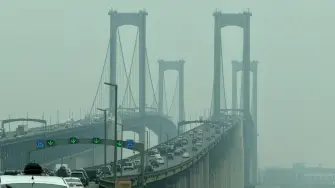 Vehículos circulan por el puente Delaware Memorial mientras el humo de los incendios forestales de Canadá provoca condiciones de bruma en New Castle, Delaware.