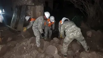 Equipos de emergencia buscando entre viviendas derrumbadas en las afueras de Huancayo.