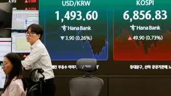 Currency dealers work as an electronic board displays the Korea Composite Stock Price Index (KOSPI), the exchange rate between the U.S. dollar and South Korean won at the dealing room of a bank, in Seoul, South Korea, July 14, 2026. REUTERS/Kim Soo-hyeon