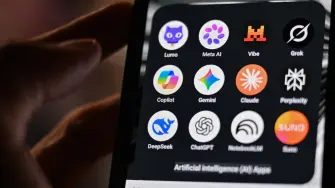 This photograph shows a handheld smartphone displaying the icons of some of the main artificial intelligence based apps, including LLMs, chatbots and generative AI, with logos (from L) of Proton AG's Lumo, Meta AI, Mistral Vibe (formerly Le Chat), xAI's Grok, Microsoft's Copilot, Google's Gemini, Anthropic's Claude, Perplexity, Deepseek, OpenAI's Chat GPT, Google's Notebook LLM and generative AI music app Suno, in Saint-Mande, east of Paris, on July 15, 2026. (Photo by Martin LELIEVRE / AFP)