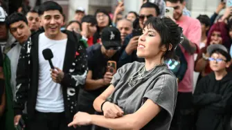 A young woman gestures to her opponent during a face-off in the so-called "Aura Battle" in Mexico City on August 20, 2026. The so-called "Aura Battle" is a new viral trend among young people in which two individuals face off in public spaces without speaking, using poses, walks, or dance moves to demonstrate who projects more charisma and style. (Photo by Yuri CORTEZ / AFP)