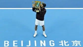 Serbias Novak Djokovic holds up the trophy as he celebrates winning the mens singles final against Australias Alex de Minaur at the China Open tennis tournament in Beijing on October 6, 2026. (Photo by ADEK BERRY / AFP)