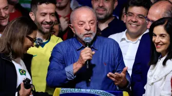 Brazil's President and re-election candidate for the Workers' Party (PT) Luiz Inacio Lula da Silva (C) speaks after knowing the first results of the presidential runoff election, in Sao Paulo, Brazil, on October 25, 2026. Lula da Silva pulled off a dramatic comeback on October 25, 2026, as he clinched election victory against right-wing senator Flavio Bolsonaro, who trounced him in the first round. (Photo by Miguel SCHINCARIOL / AFP)