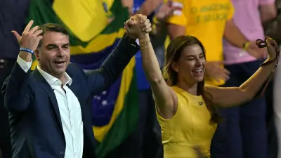 El aspirante presidencial derechista de Brasil, Flavio Bolsonaro, saluda junto a su esposa, Fernanda Bolsonaro, durante el lanzamiento de su candidatura en la convención del Partido Liberal (PL).