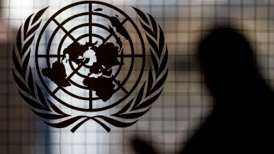 (FILES) A person walks past the UN logo at UN headquarters in New York City on February 8, 2024. All seven candidates to lead the United Nations received a vote of 