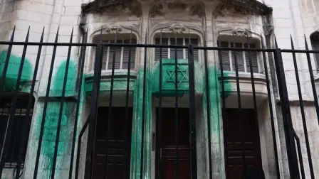 Una fotografía muestra pintura verde arrojada sobre las paredes de la sinagoga Agoudas Hakehilos en París.