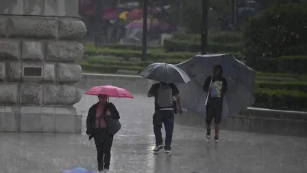 Personas se refugian bajo paraguas de la lluvia en la Ciudad de México.