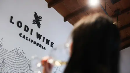 Un visitante toma un sorbo de vino durante una cata de vinos locales en el centro de visitantes de Lodi, California.