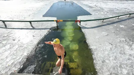 Un aficionado a la natación invernal hace un gesto después de nadar en el lago Houhai.