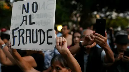 Un manifestante muestra un cartel que dice "No al Fraude".