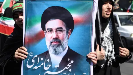 Una mujer iraní sostiene la imagen del Ayatollah Mojtaba Jamenei.