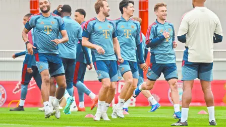 Bayern Munich's German defender #04 Jonathan Tah (L), Bayern Munich's German midfielder #06 Joshua Kimmich (2R), Bayern Munich's English forward #09 Harry Kane (2L) and team mates warm up with Bayern Munich's Belgian head coach Vincent Kompany (R) during a training session of FC Bayern Munich at their training ground in the Saebener Strasse in Munich, southern Germany on May 5, 2026, the eve of the UEFA Champions League second-leg semi-final football match against Paris Saint-Germain (PSG). (Photo by Alexandra BEIER / AFP)